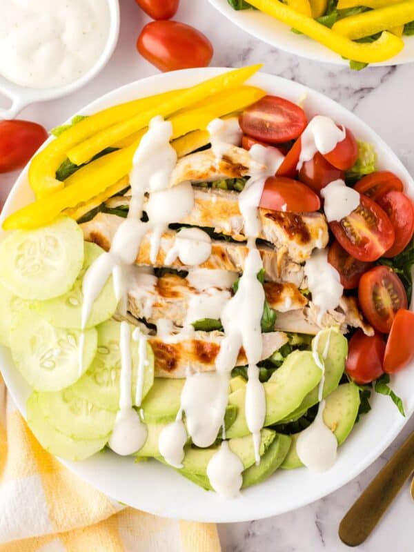 rainbow Grilled chicken salad on a white plate.