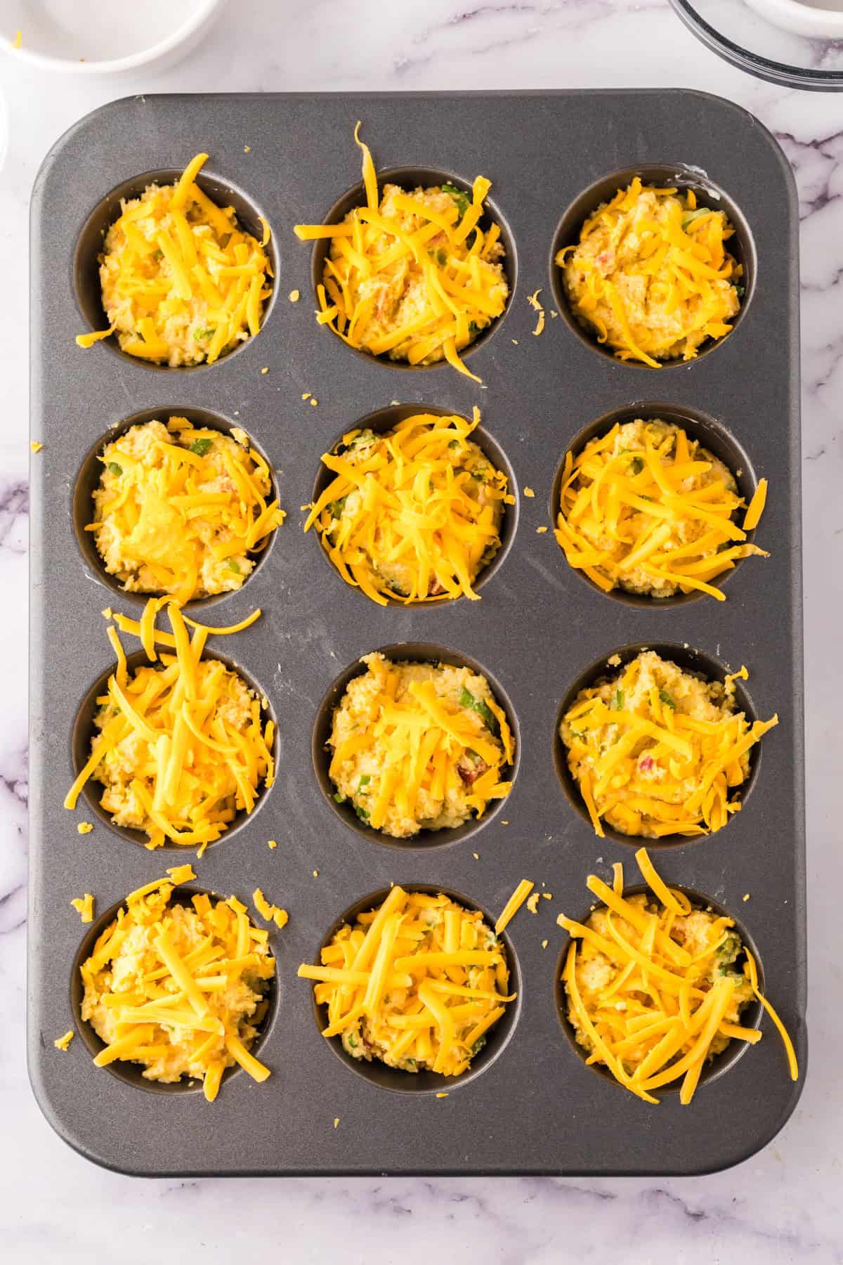 cheesy savory bacon cornbread muffins in the tin.