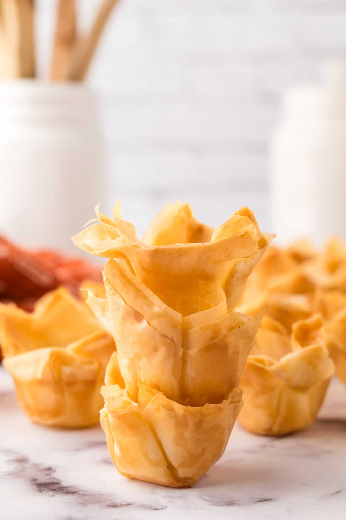 three homemade phyllo cup recipe stacked on the counter.
