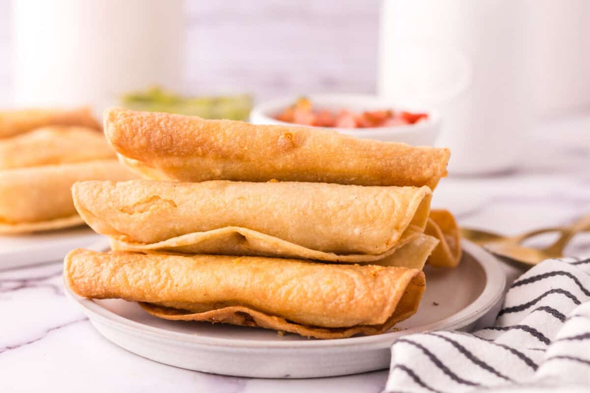 Leftover turkey taquitos stacked on a plate.