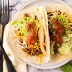two lentil tacos on a white plate.