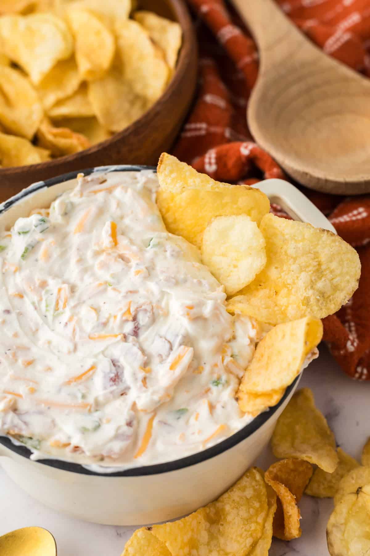loaded baked potato dip in a bowl with potato chips.