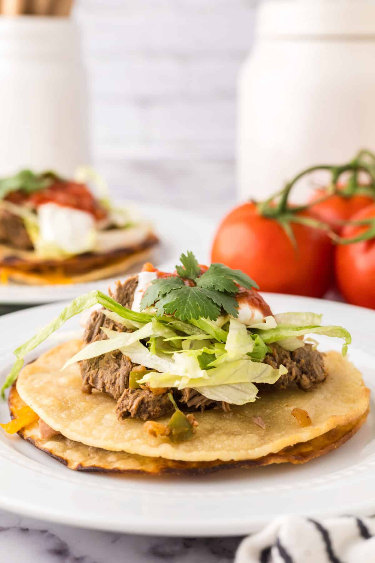 beef piled high with cilantro on top to make Mexican beef tostados.