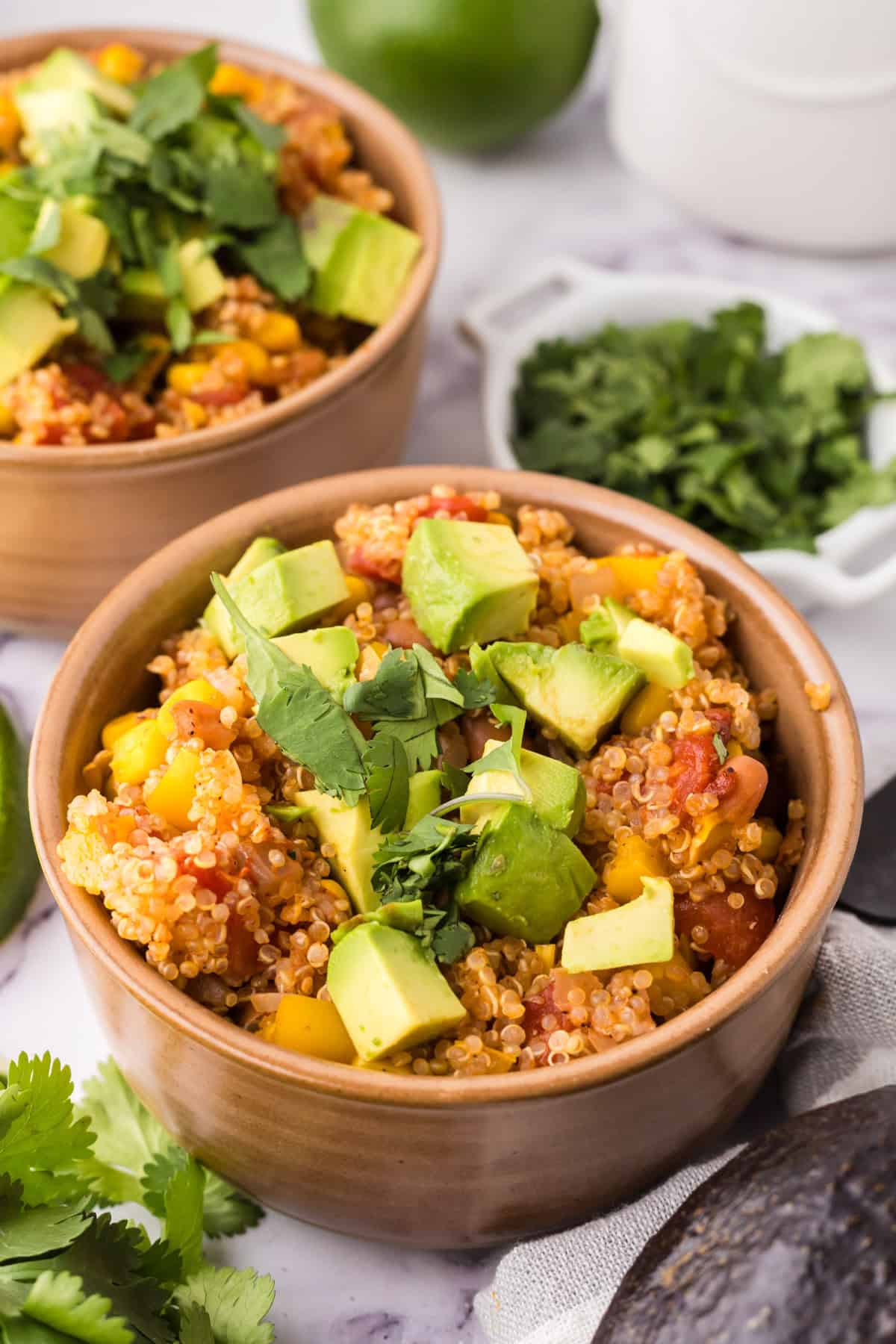 bowls with one pot quinoa taco casserole recipe with avocado and cilantro on top.