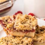 round white plate with squares of raspberry streusel bars.