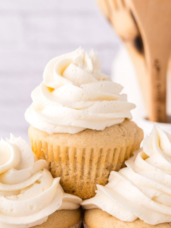 Copycat vanilla cupcakes with vanilla frosting on top in a swirl.