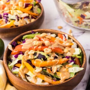 wooden salad bowl with asian chicken salad with peanut dressing.