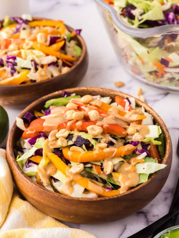 wooden salad bowl with asian chicken salad with peanut dressing.