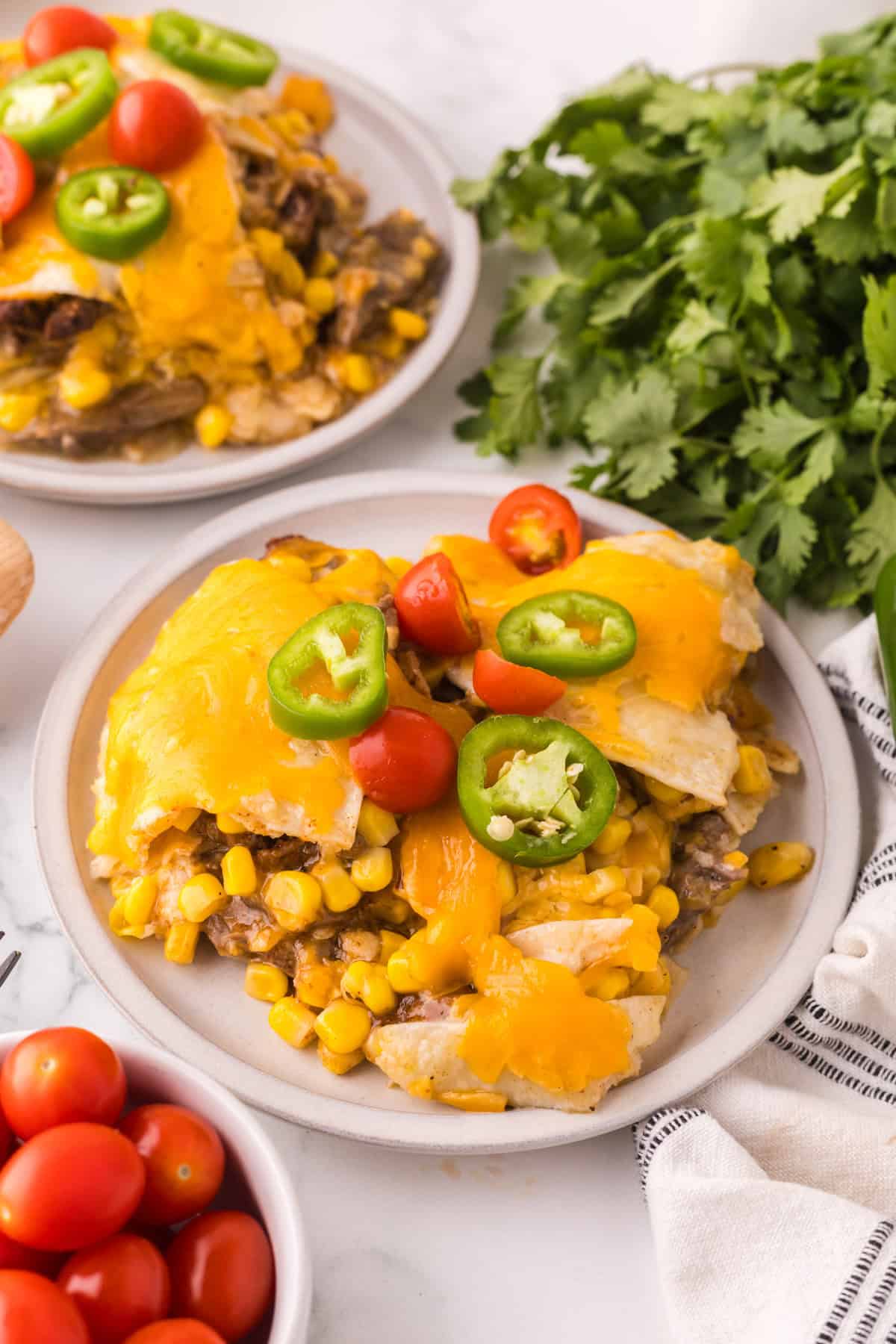 beef and corn enchilada bake on a round white serving plate.