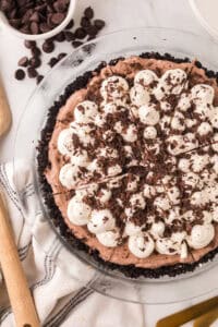 whole chocolate cream pie recipe with dollops of cream and chocolate on top.
