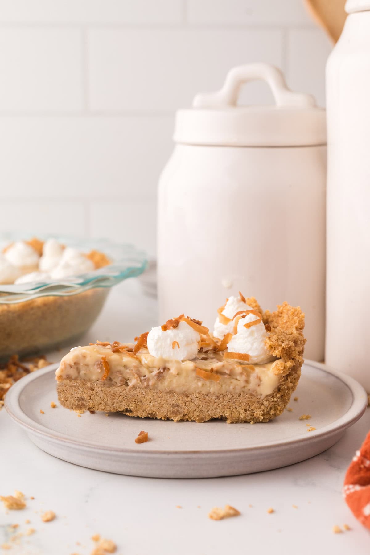 slice of coconut cream pie with dollops of cream on top.