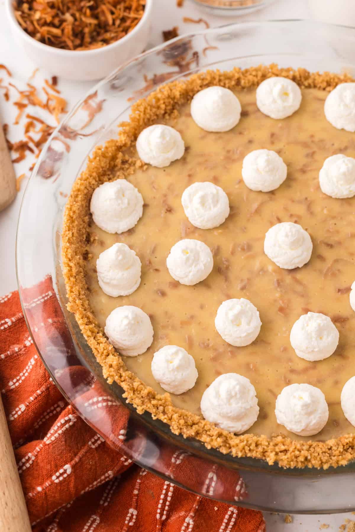 whole coconut cream pie with dollops of cream on top.