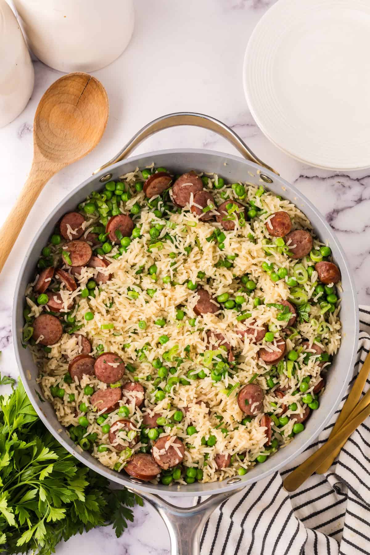 one pot sausage peas and rice in a pan in the progress of cooking.