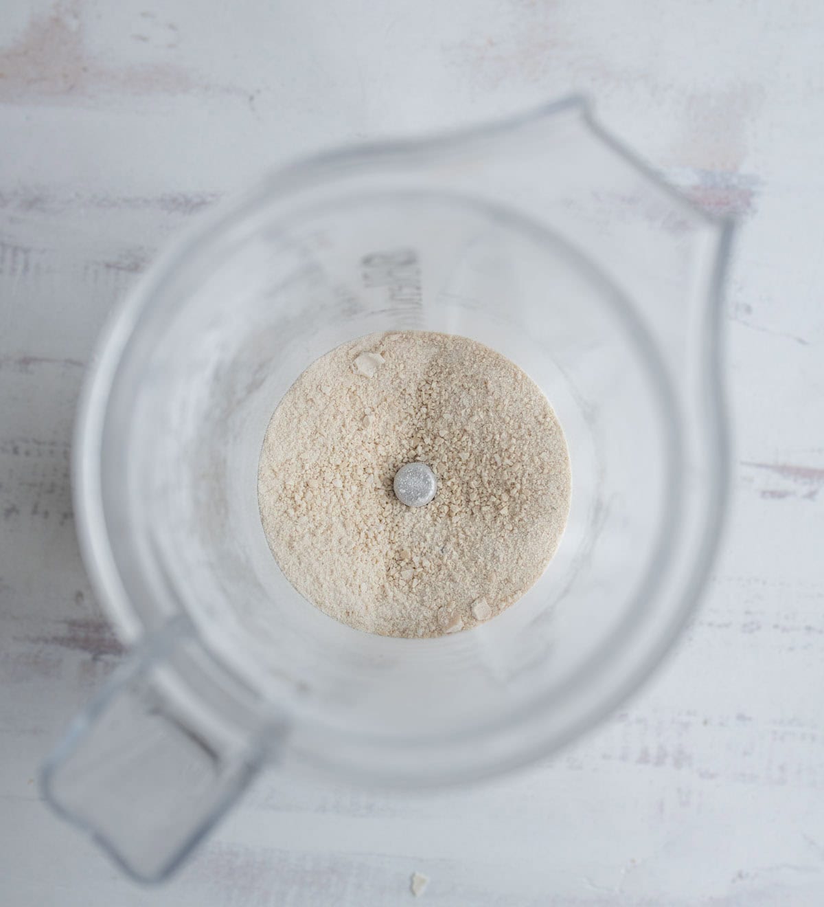 A blender with a white bowl of flour.
