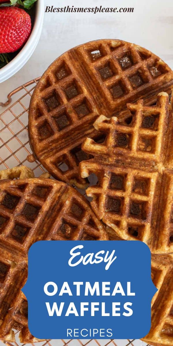 Top view of golden-brown oatmeal waffles on a cooling rack, with a bowl of sliced strawberries in the corner. A banner reads Easy Oatmeal Waffles Recipes.