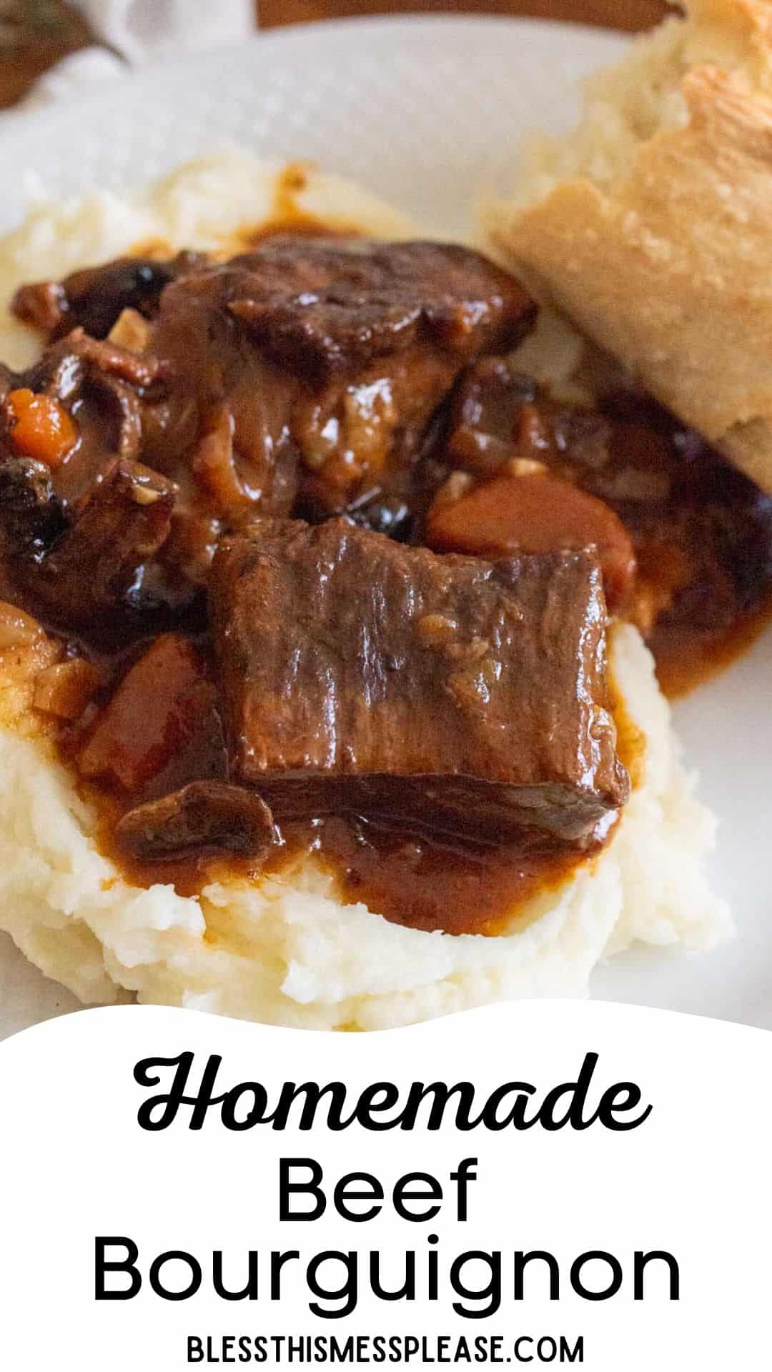 A plate of homemade beef bourguignon served over mashed potatoes, with a piece of bread on the side. The dish includes tender beef pieces and vegetables in a rich sauce.