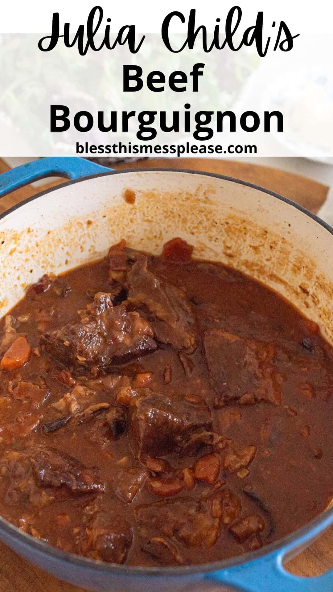 A blue pot filled with beef bourguignon, which is a rich, dark stew with chunks of beef and visible pieces of carrots. The text above reads Julia Childs Beef Bourguignon and the website blessthismessplease.com.
