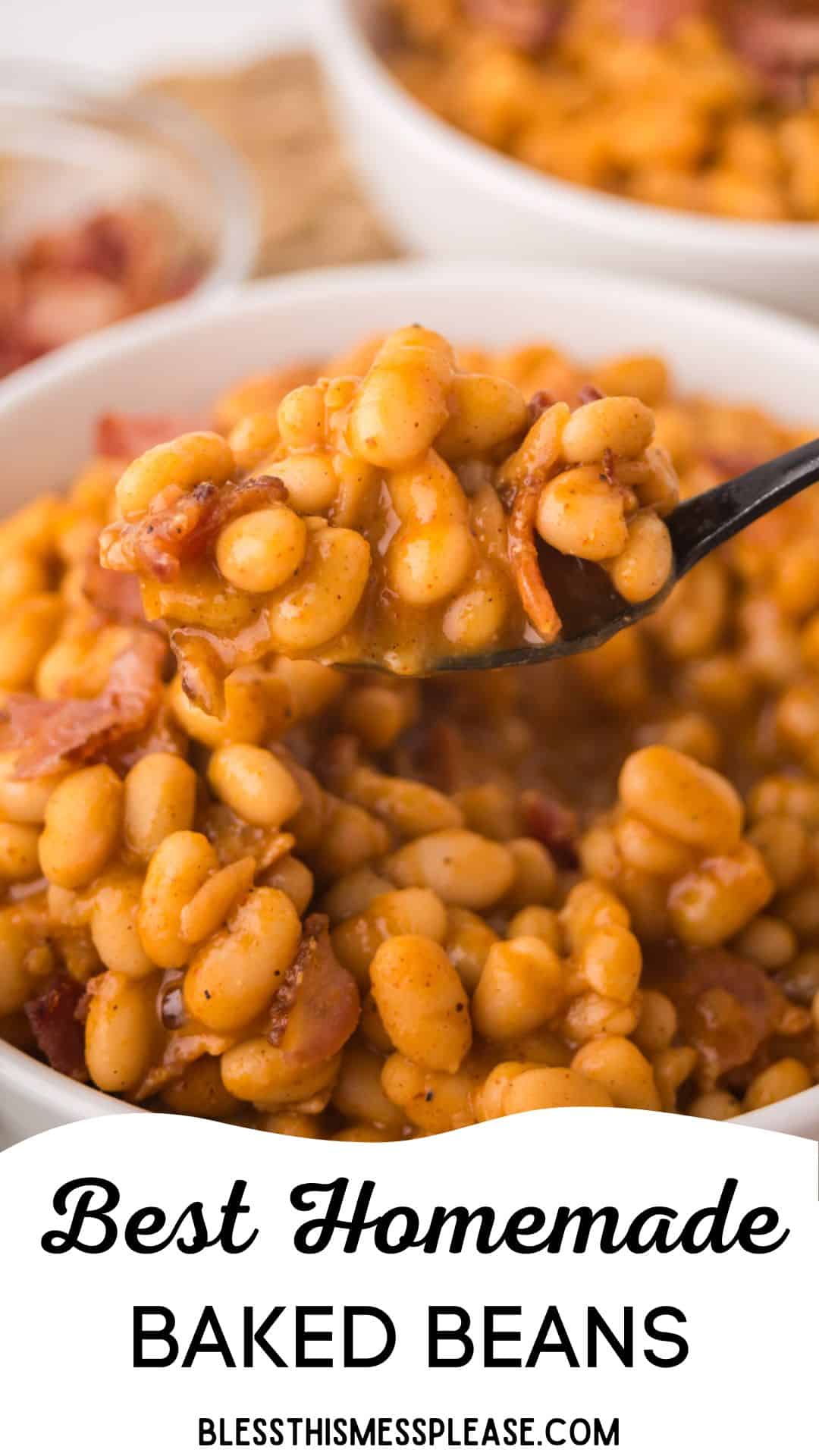 A close-up of a spoonful of homemade baked beans with pieces of bacon being lifted from a bowl. Text at the bottom reads Best Homemade Baked Beans and blessthismessplease.com.