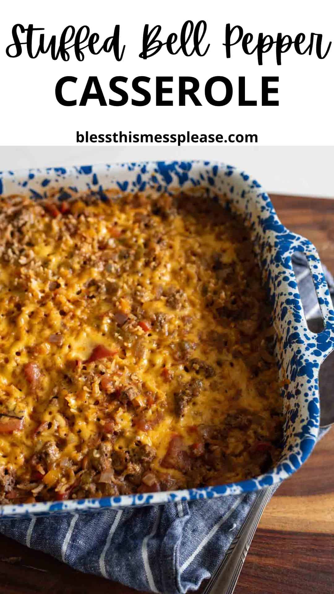 A blue and white speckled baking dish filled with cheesy stuffed bell pepper casserole sits on a striped kitchen towel atop a wooden surface. Text above reads “Stuffed Bell Pepper Casserole.”.