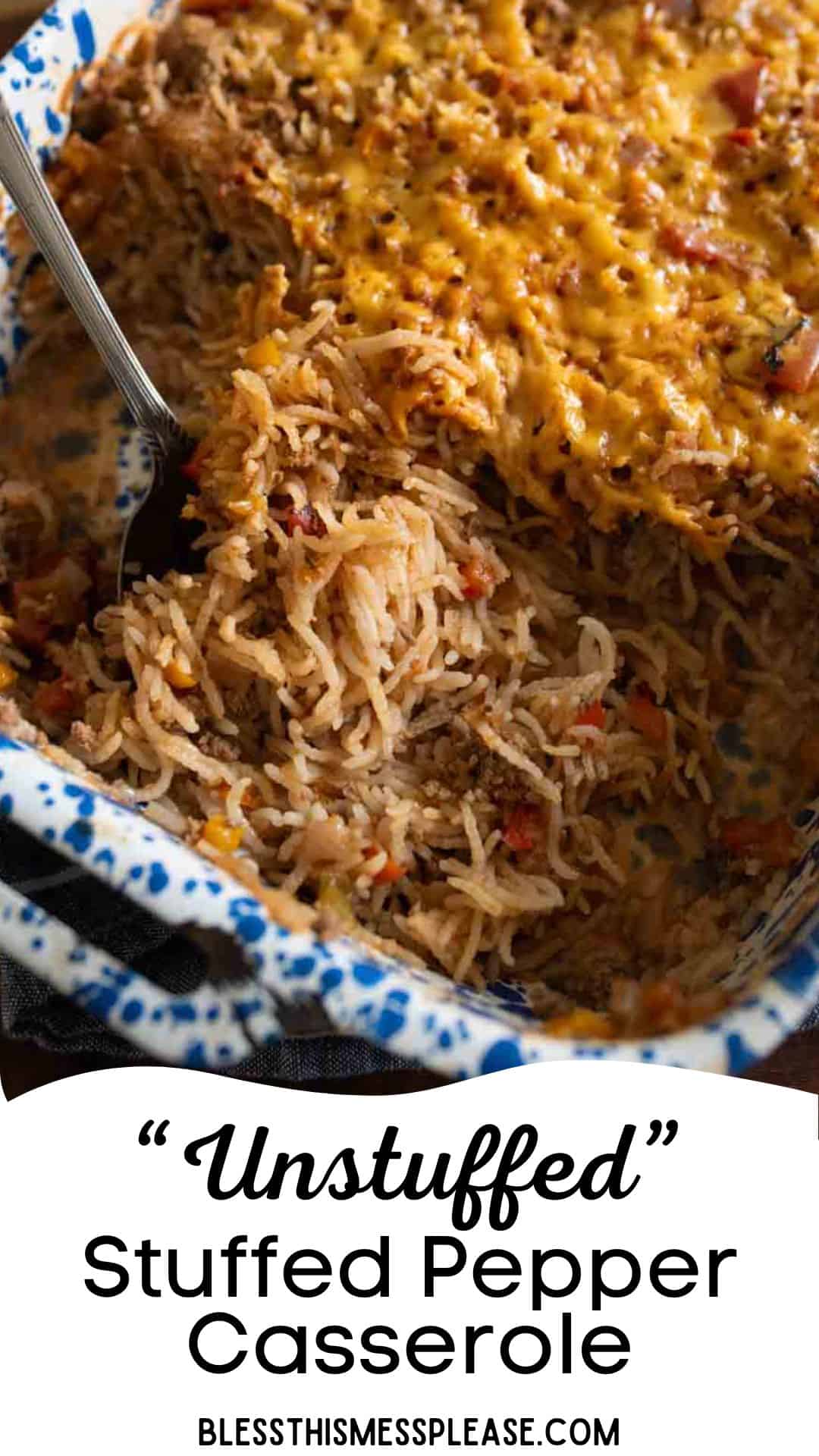 A close-up of a casserole dish filled with stuffed bell pepper casserole, featuring rice, ground meat, chopped peppers, and melted cheese. A spoon is scooping out a serving while the dish rests on a dark surface.