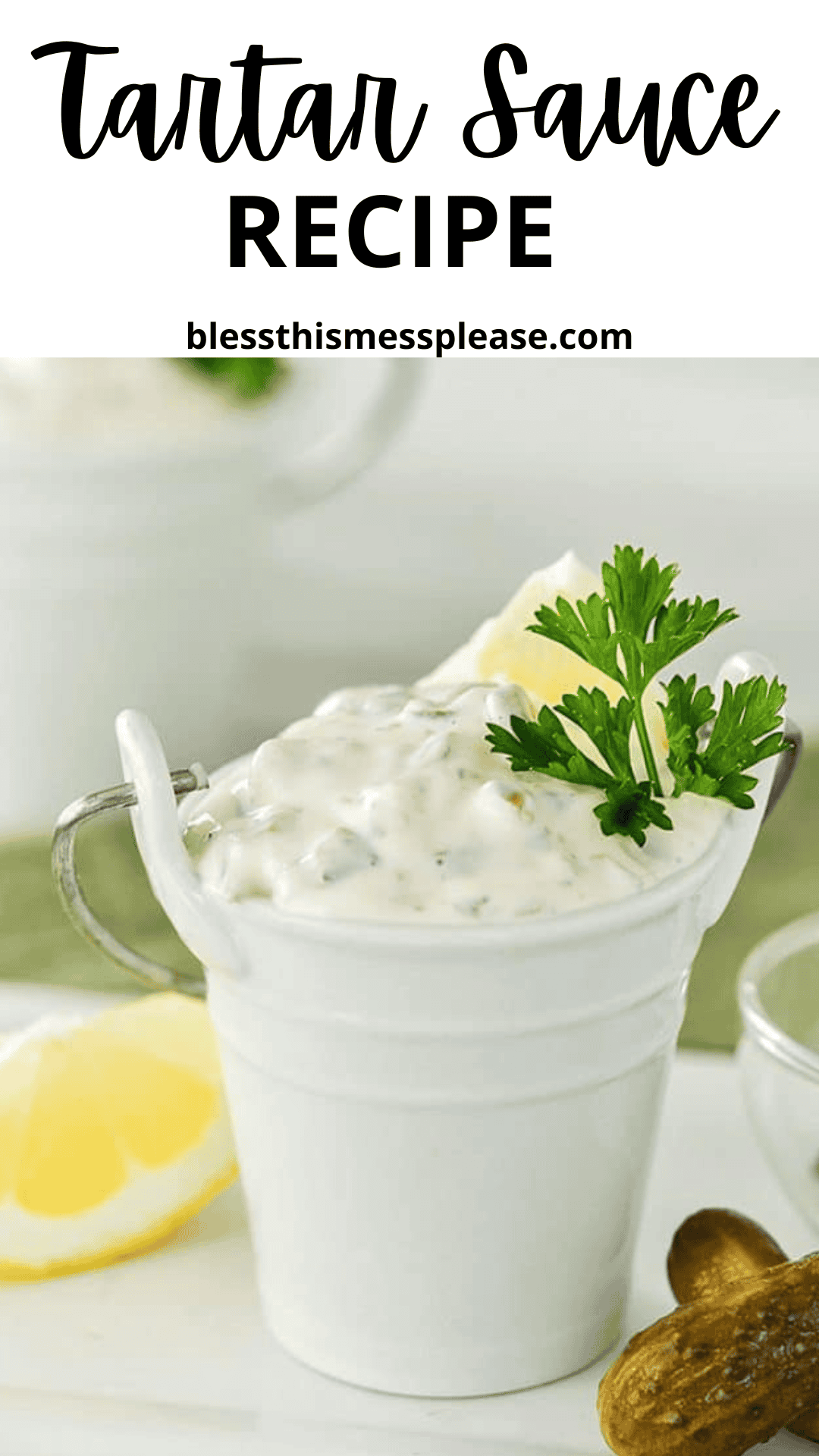 A small white pail filled with creamy tartar sauce recipe, garnished with fresh parsley, sits next to lemon wedges and pickles. Text at the top reads “Tartar Sauce Recipe” and “blessthismessplease.com.”.