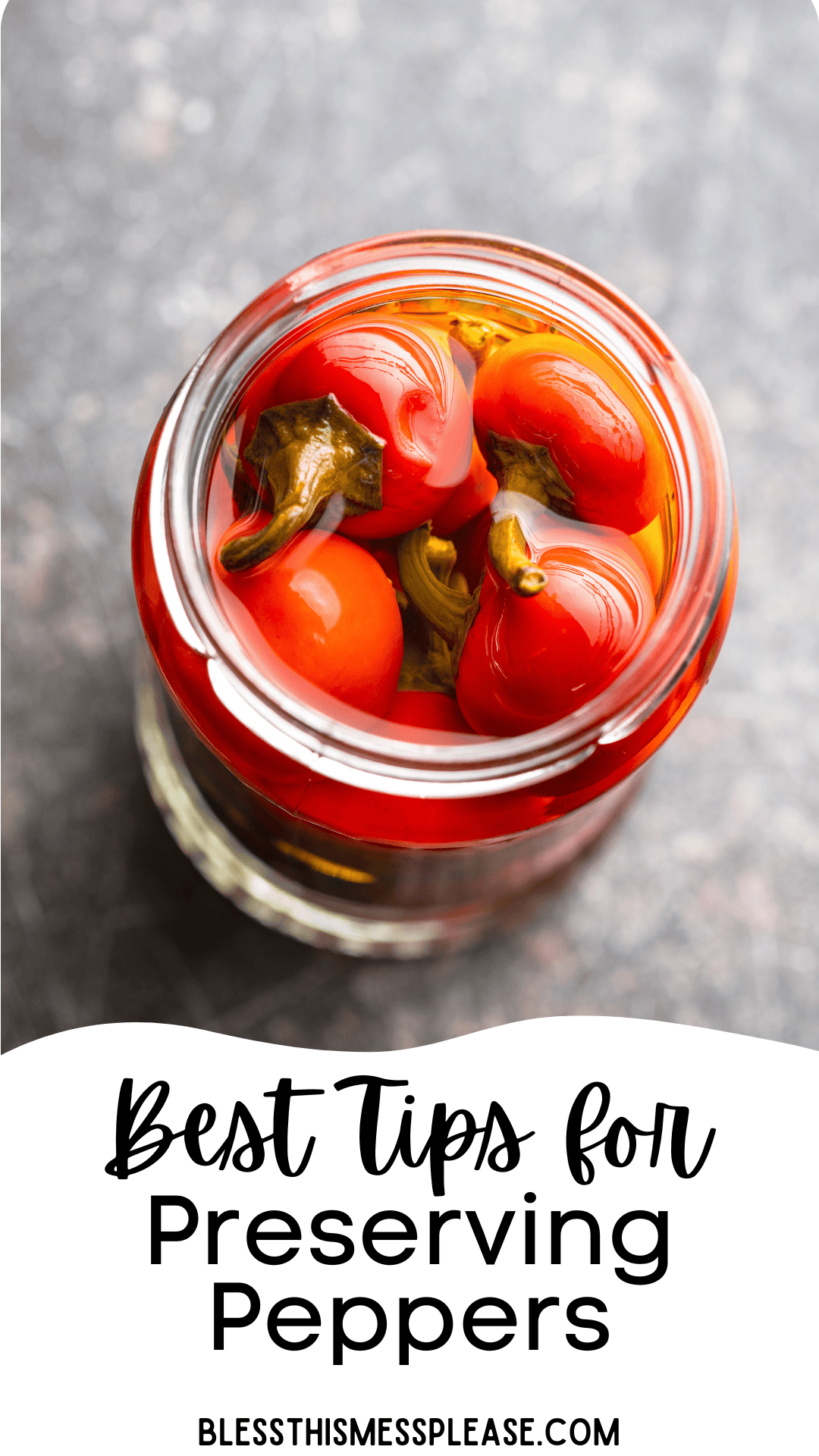 A glass jar filled with bright red peppers in liquid sits on a dark surface. Text below reads: Best Tips for How to Preserve Peppers. blessthismessplease.com.