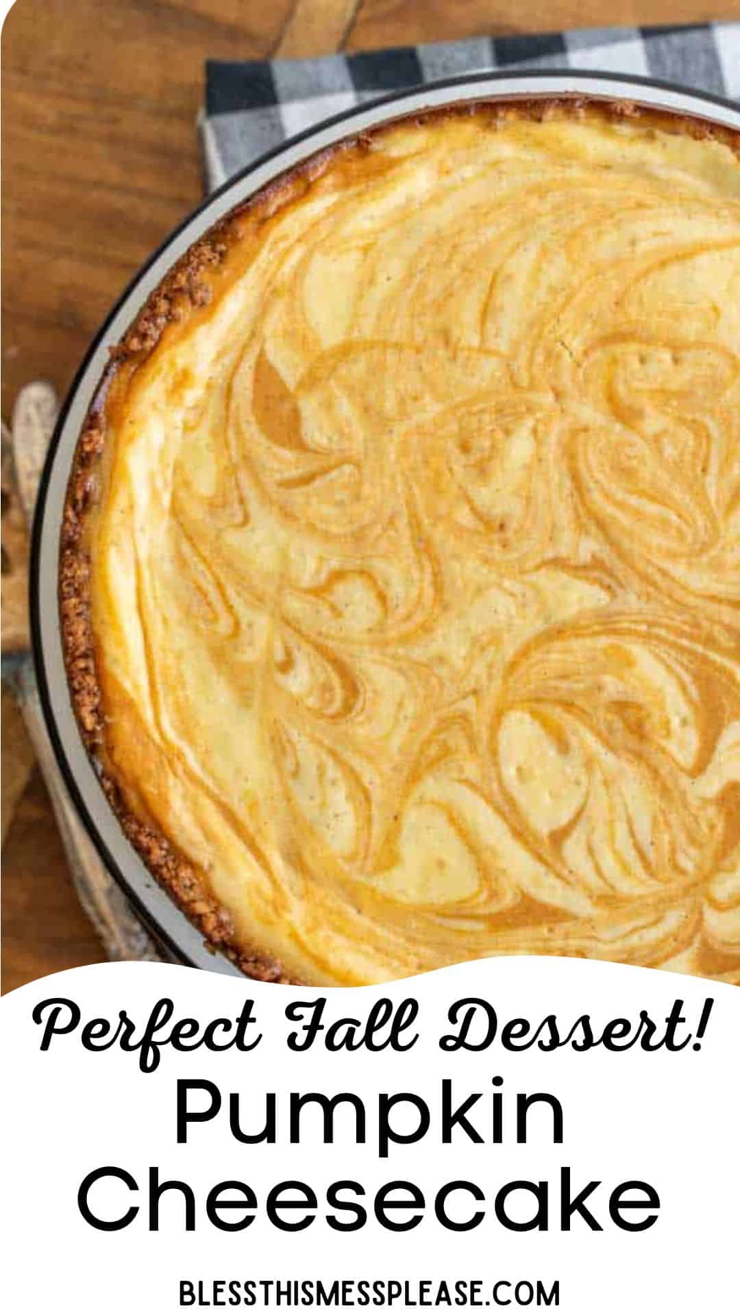 A pumpkin cheesecake recipe with a marbled orange and cream swirl top, set on a wooden table with a checkered cloth. Text reads: Perfect Fall Dessert! Pumpkin Cheesecake. blessthismessplease.com.