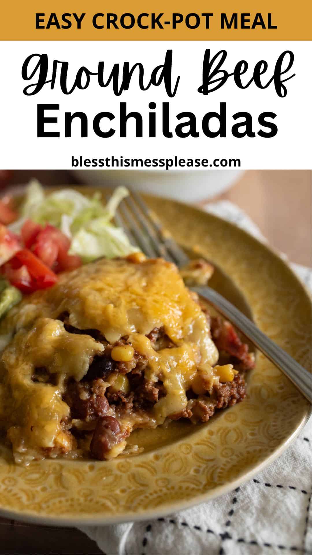 A plate of crock pot beef enchiladas topped with melted cheese, served with chopped tomatoes and lettuce on the side; a fork rests on the yellow plate. Text above reads Easy Crock-Pot Meal: Ground Beef Enchiladas.