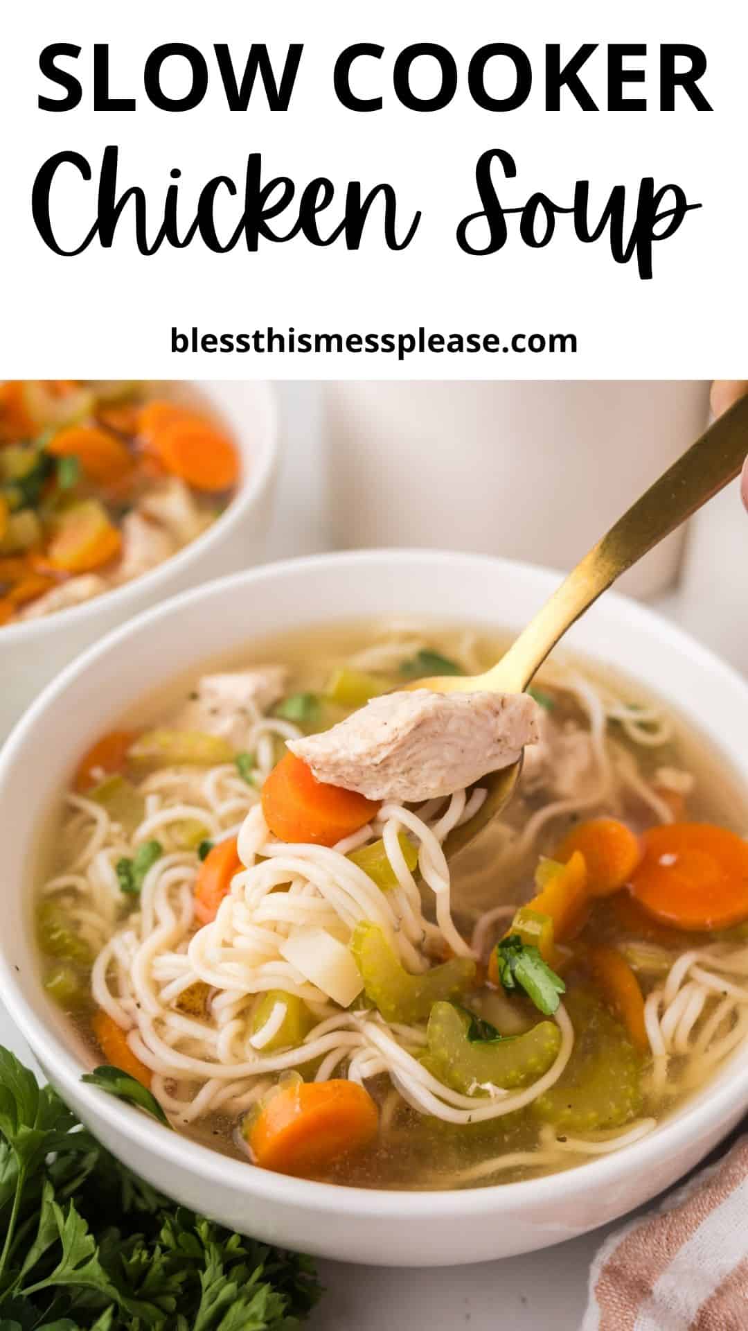 A bowl of slow cooker chicken soup with noodles, carrots, and celery sits on a table. A spoon lifts tender chicken from the bowl. Fresh parsley and another bowl of soup are nearby. Text above reads, “Slow Cooker Chicken Soup.”.