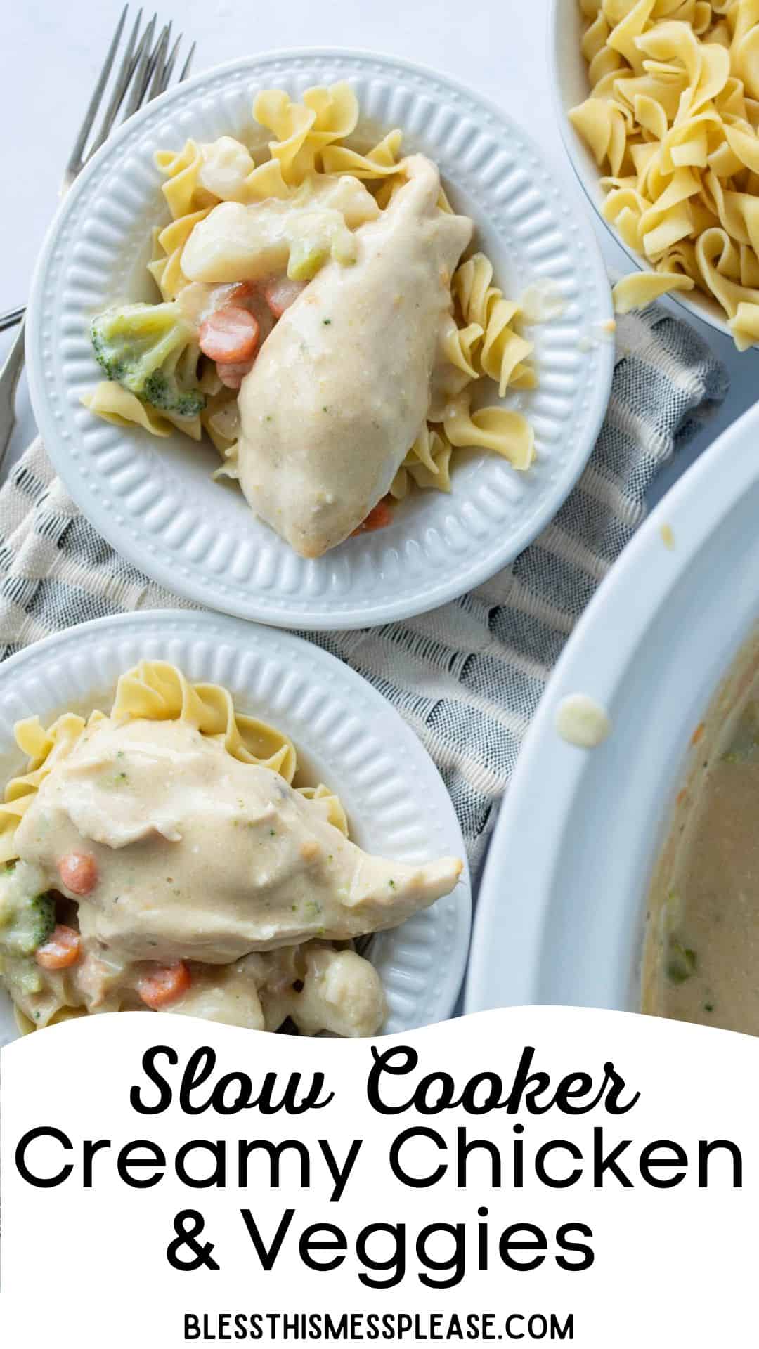 Two plates of egg noodles topped with slow cooker creamy chicken, carrots, and broccoli rest on a striped cloth napkin beside a slow cooker filled with more creamy chicken and a bowl of plain noodles.