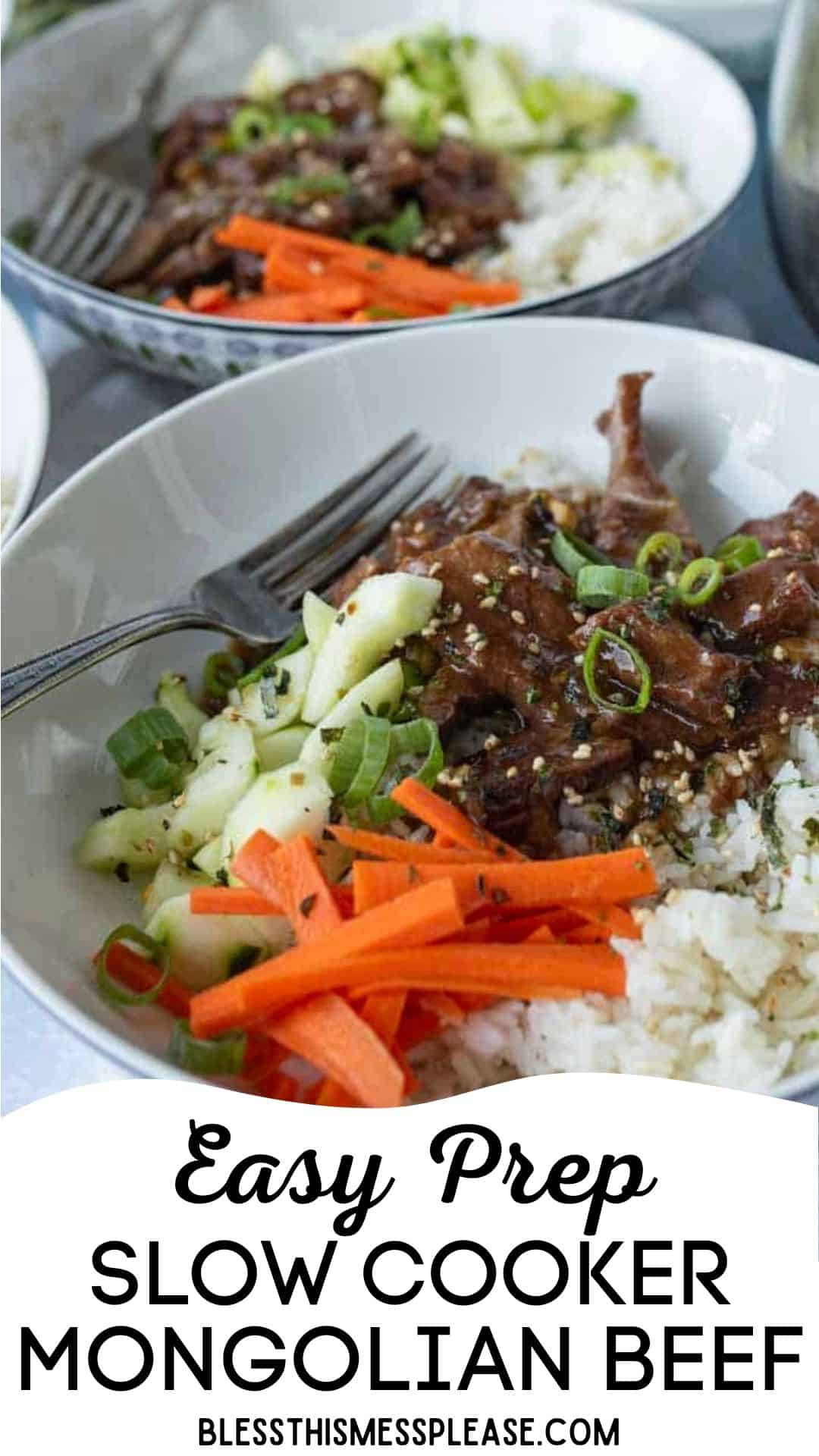 A bowl of slow cooker Mongolian beef served over white rice, topped with sliced green onions, cucumber, and carrot sticks. A fork rests beside this easy prep slow cooker Mongolian beef dish.