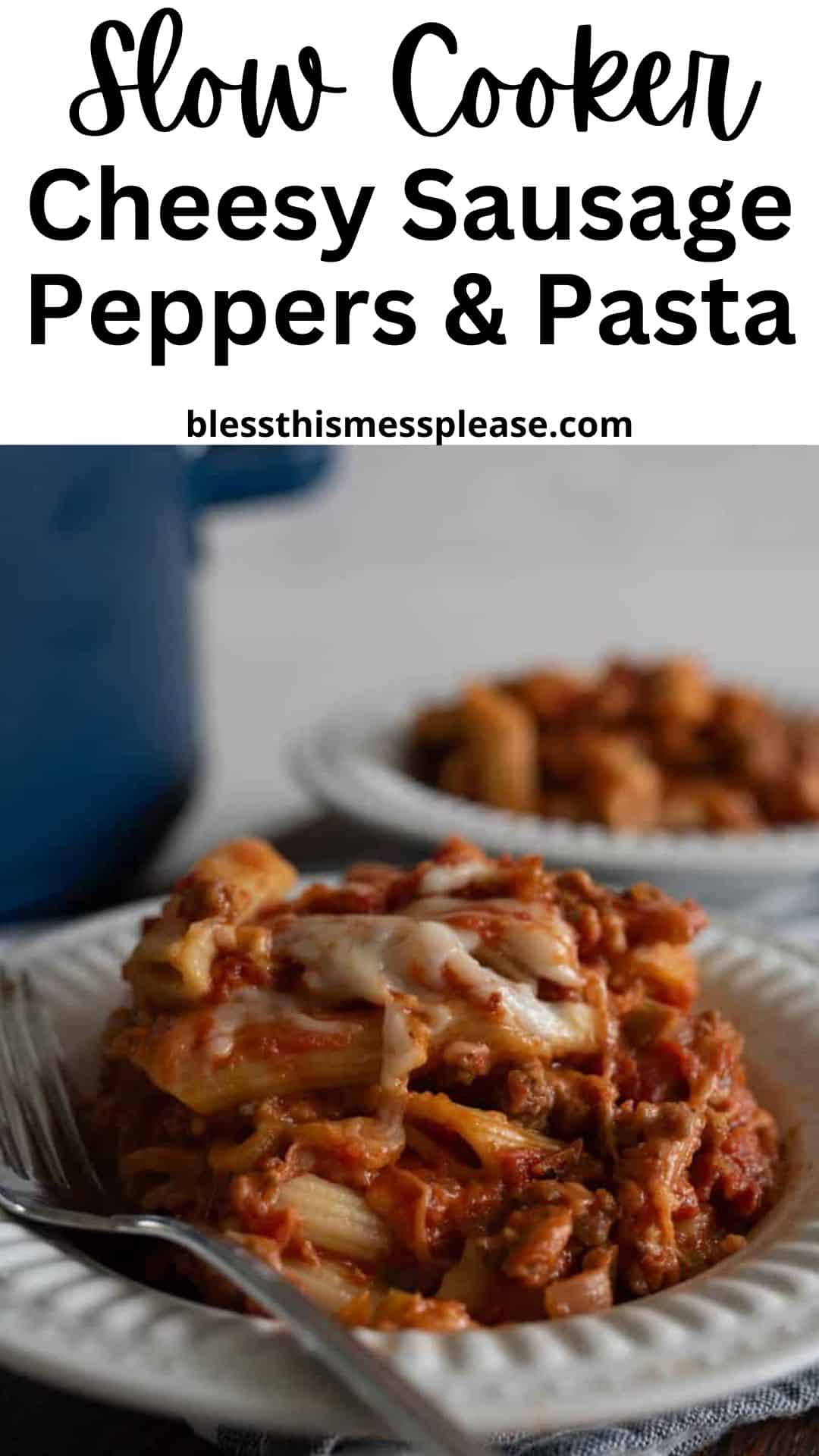 A plate of slow cooker sausage peppers and cheesy pasta is served on a white dish, with another plate in the background. The text above reads, Slow Cooker Cheesy Sausage Peppers & Pasta blessthismessplease.com.