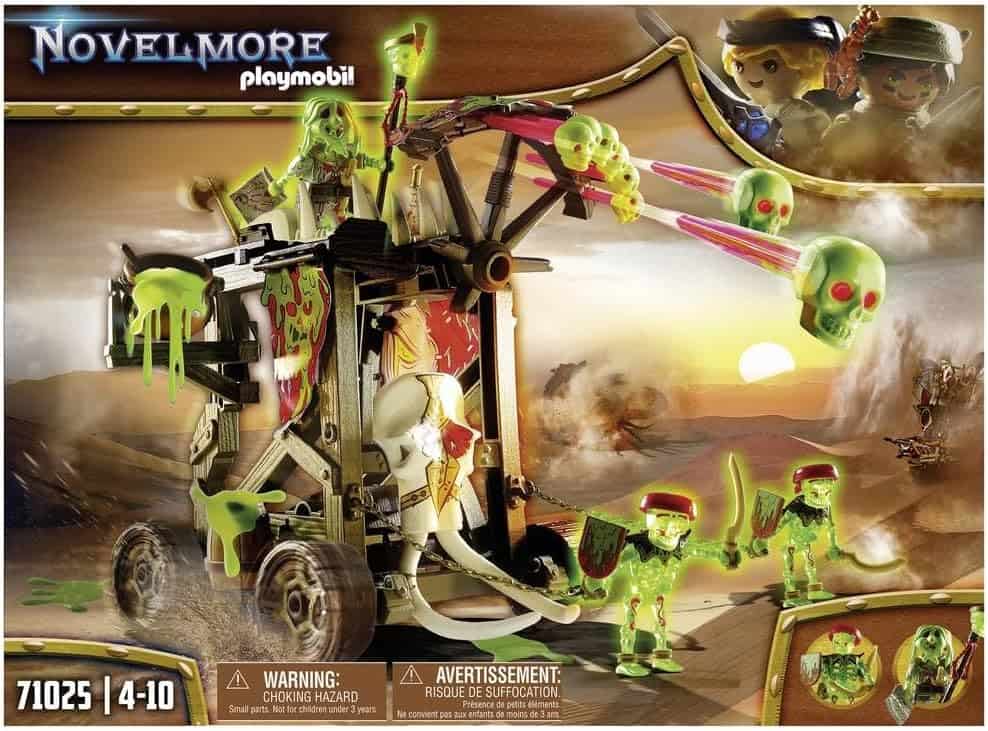 Box art for a Playmobil Novelmore set shows a spooky catapult launching glowing green skulls, with skeleton warriors and green slime in a desert landscape. Set number 71025, recommended for ages 4–10.