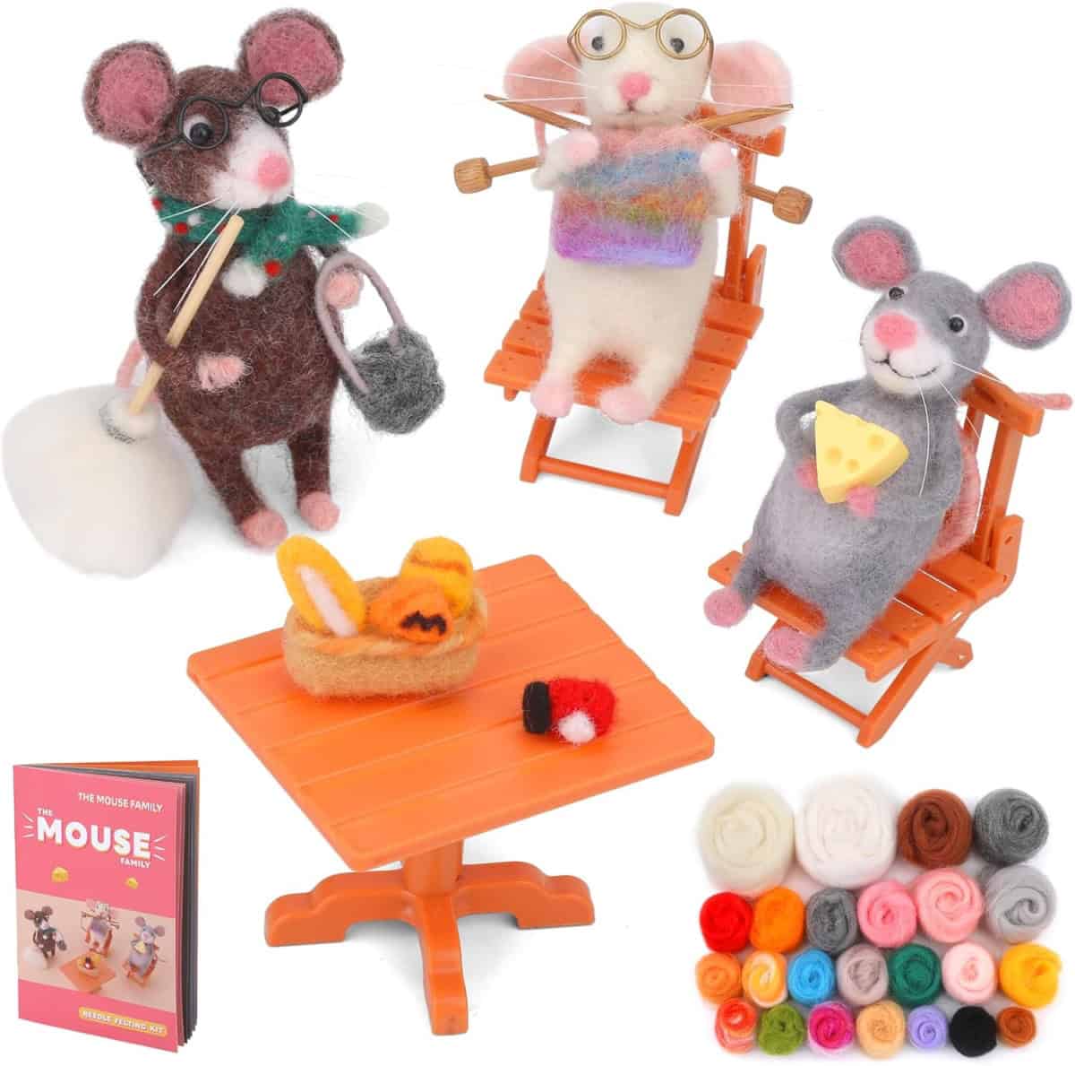 Three felt mouse figurines sit on orange chairs around an orange table with felt food items. There is a booklet titled “The Mouse Family” and a selection of colorful felt balls in the corner.