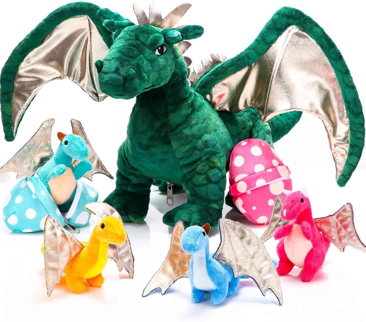 A large green plush dragon with metallic wings sits behind four smaller colorful dragon plushies (blue, yellow, pink, and turquoise), each with silver wings and a spotted plush egg nearby.