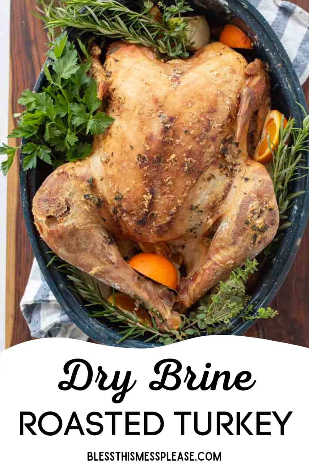 A golden-brown dry brine turkey in a pan, surrounded by fresh herbs and orange slices, with the text “Dry Brine Roasted Turkey” and “blessthismessplease.com” at the bottom.