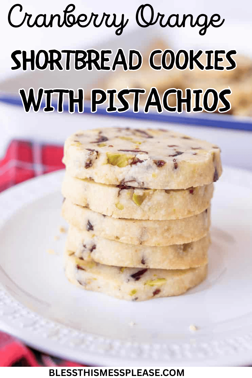 A stack of cranberry orange shortbread cookies with pistachios sits on a white plate. The tender cookies feature visible pieces of cranberry and pistachio, while text over the image highlights “cranberry orange shortbread cookies.”.