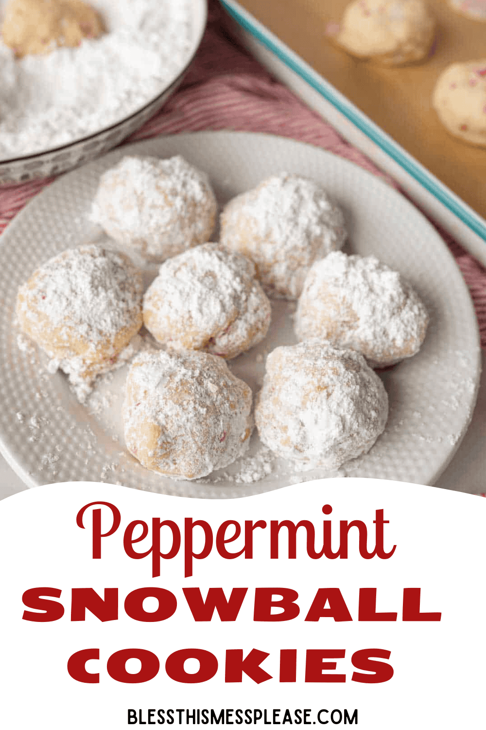 A plate of peppermint snowball cookies dusted with powdered sugar sits next to a baking sheet and a bowl of powdered sugar. Text at the bottom reads: Peppermint Snowball Cookies. Website: blessthismessplease.com.